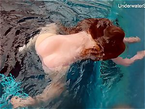ginger-haired Simonna showcasing her figure underwater